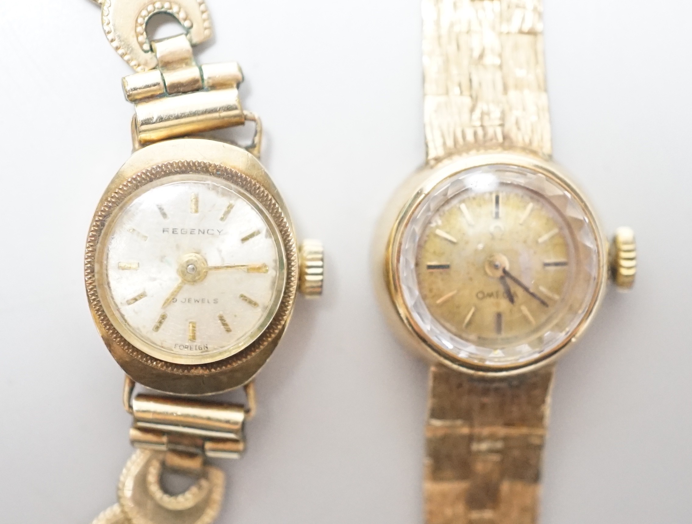 A lady's 9ct gold Omega manual wind wrist watch, on associated 9ct gold bracelet, overall 15.8cm, gross weight 17.8 grams and one other lady's 9ct gold watch on a gold plated bracelet.